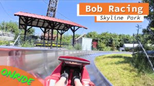 Blick aus der Fahrerperspektive auf der Bob Racing Sommerrodelbahn im Skyline Park mit Sicht auf die Strecke und die Umgebung.