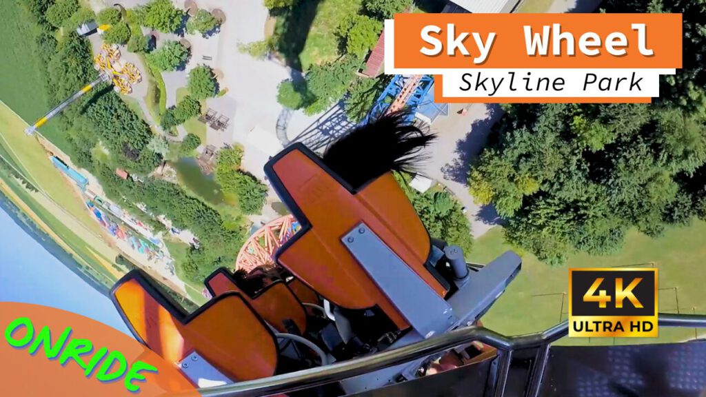 Onride-Perspektive der Sky Wheel Achterbahn im Skyline Park, mit Blick auf die orangefarbenen Sitze und die vertikale Strecke über dem Parkgelände.