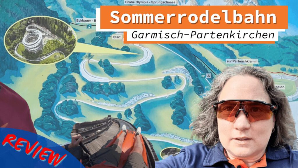 Person mit Sonnenbrille vor einer Karte der Sommerrodelbahn in Garmisch-Partenkirchen. Im Hintergrund Streckenverlauf der Rodelbahn und ein Detailbild der Strecke. Eine Rodelperspektive und der Schriftzug „Review“ ergänzen das Bild.