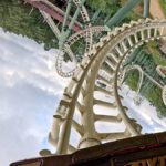 Perspektive aus der Python-Achterbahn mit Blick auf mehrere Loopings und verschlungene Schienen, während sich der Zug in einer steilen Kurve befindet.