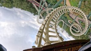 Perspektive aus der Python-Achterbahn mit Blick auf mehrere Loopings und verschlungene Schienen, während sich der Zug in einer steilen Kurve befindet.
